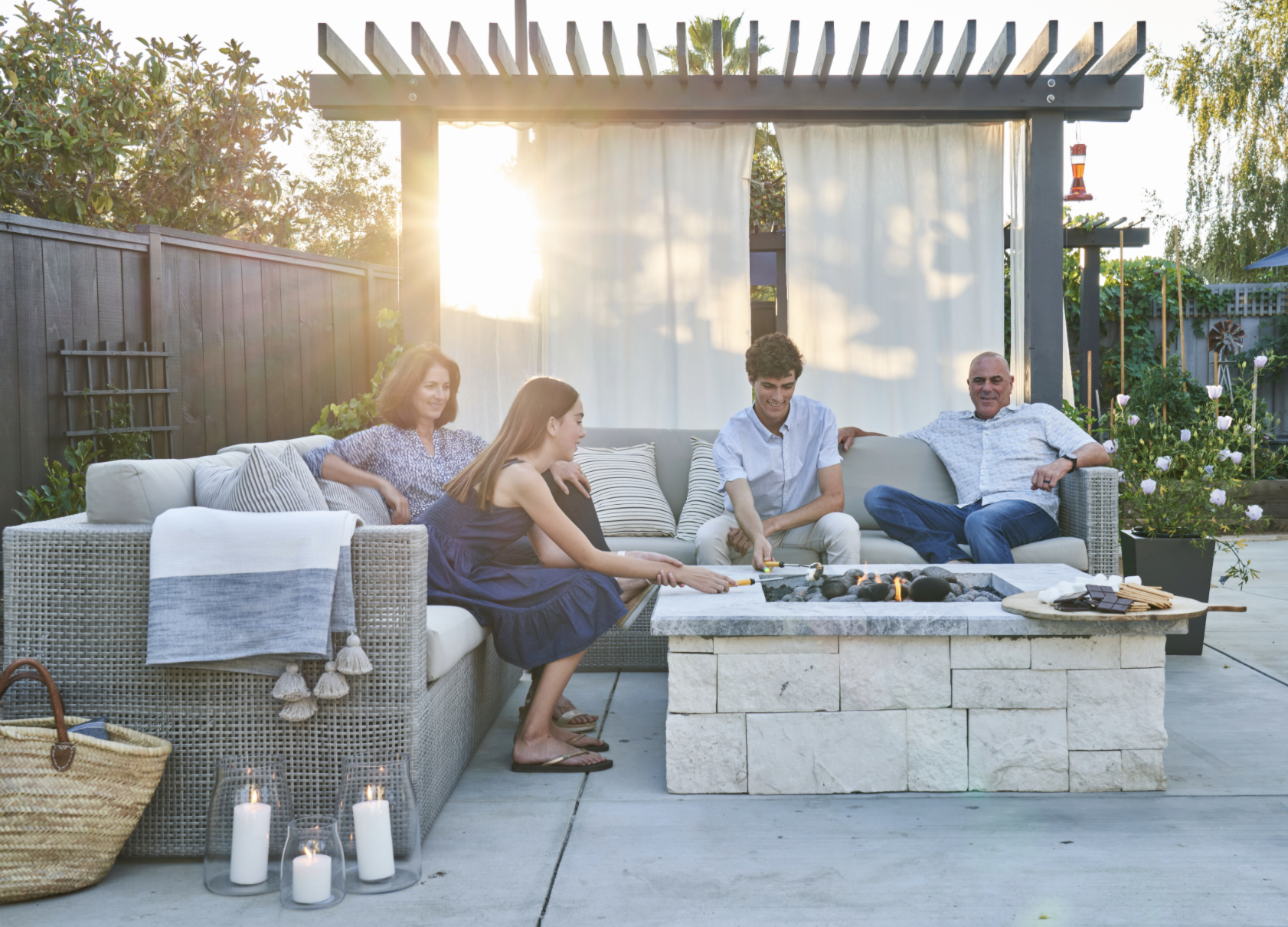 An outdoor fire pit and couches makes this outdoor living room, by Yardzen, the favorite family hang out.