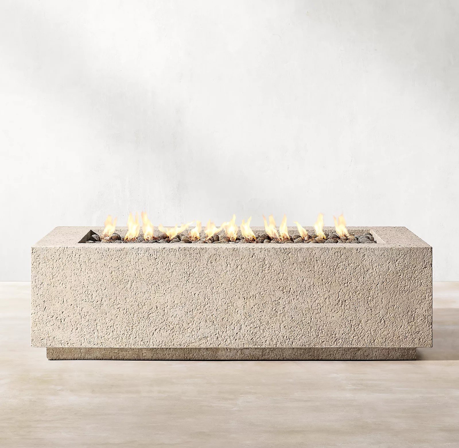 RH’s Yountville Rectangular Fire Table - Pairing minimalist geometry with rustic, hand-hewn texture, the Yountville gas fire pit table offers a bold, elemental presence outdoors. Masterfully crafted of concrete composite for the look of weathered stone with natural lava rock, it is a durable, lighter-weight alternative to pure concrete or stone, and is rated at 65,000 BTUs.SHOP NOW >