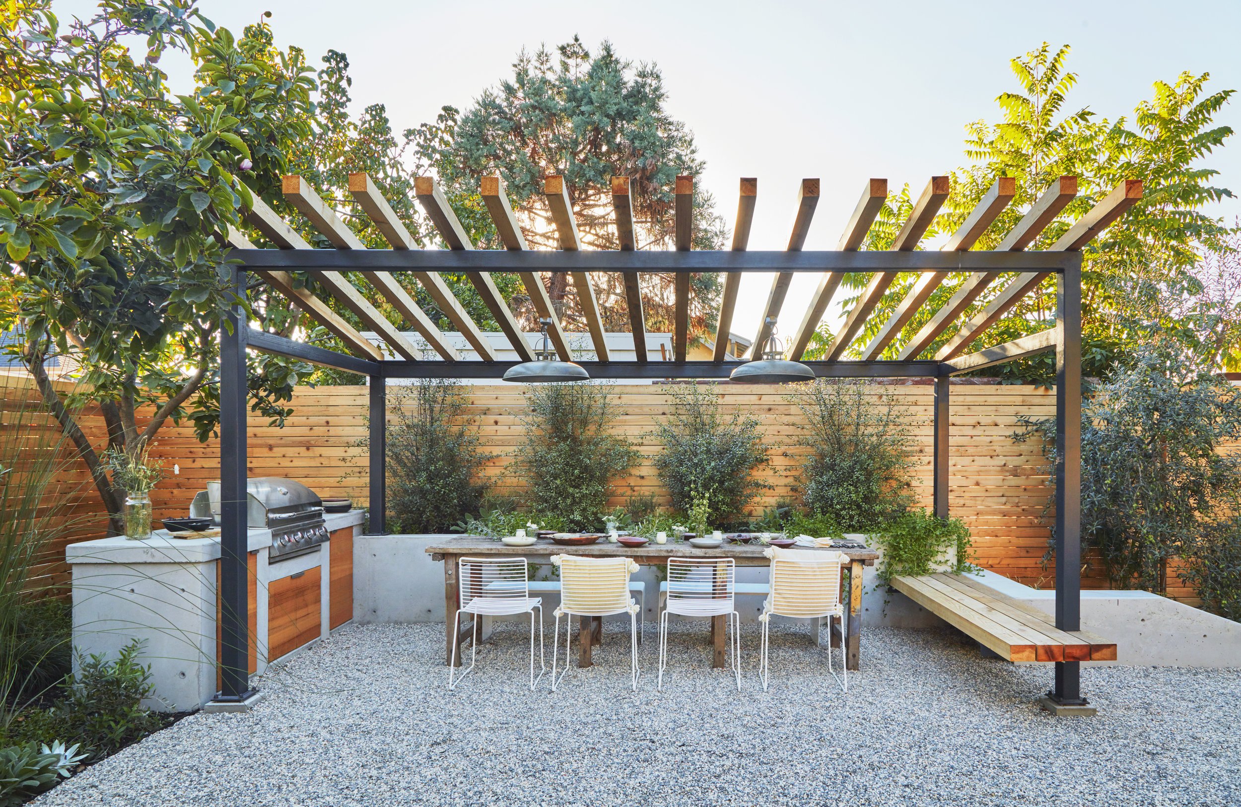 Backyard design with metal pergola, bbq, and outdoor dining area