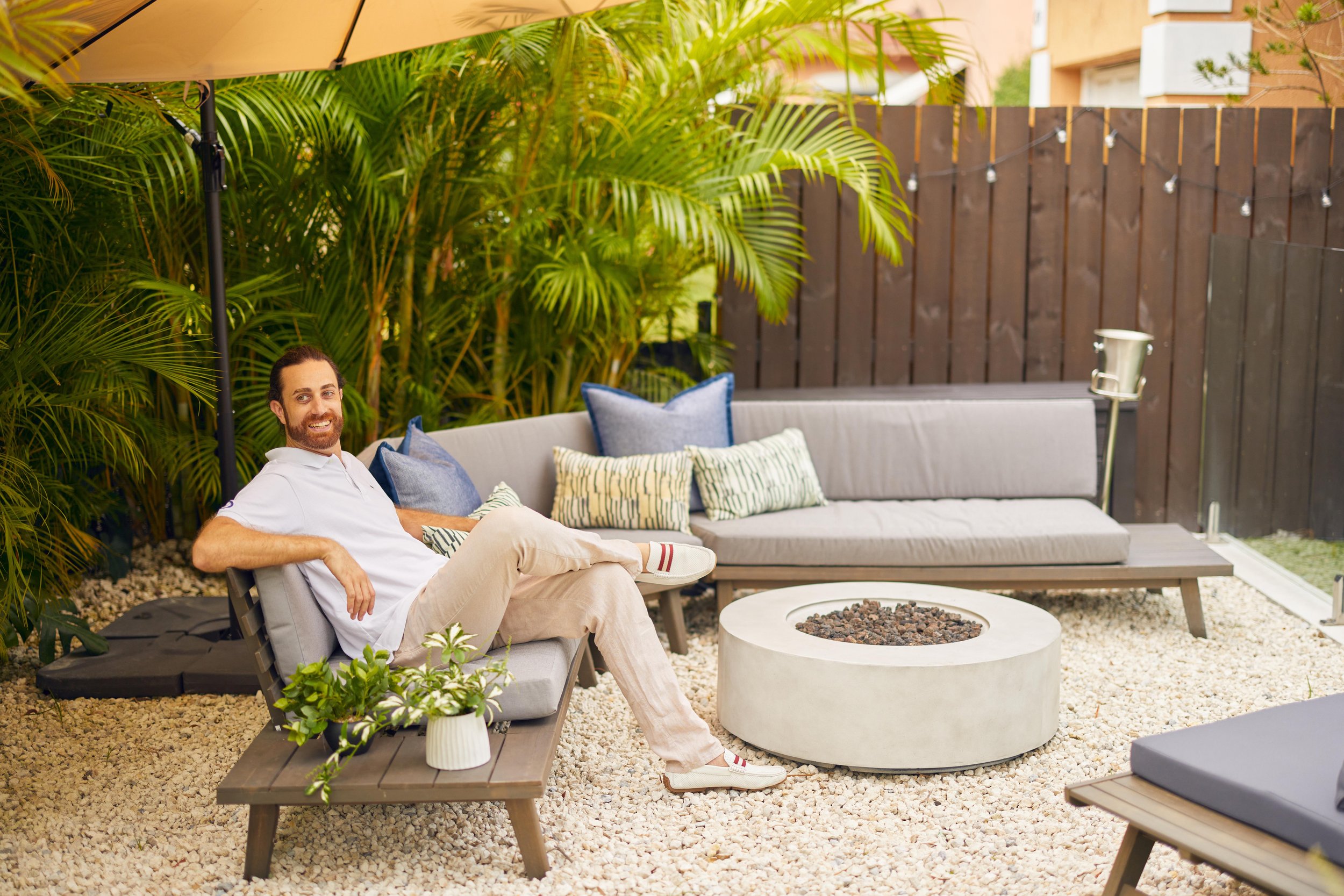 Yardzen client enjoys outdoor fire pit area in Miami backyard
