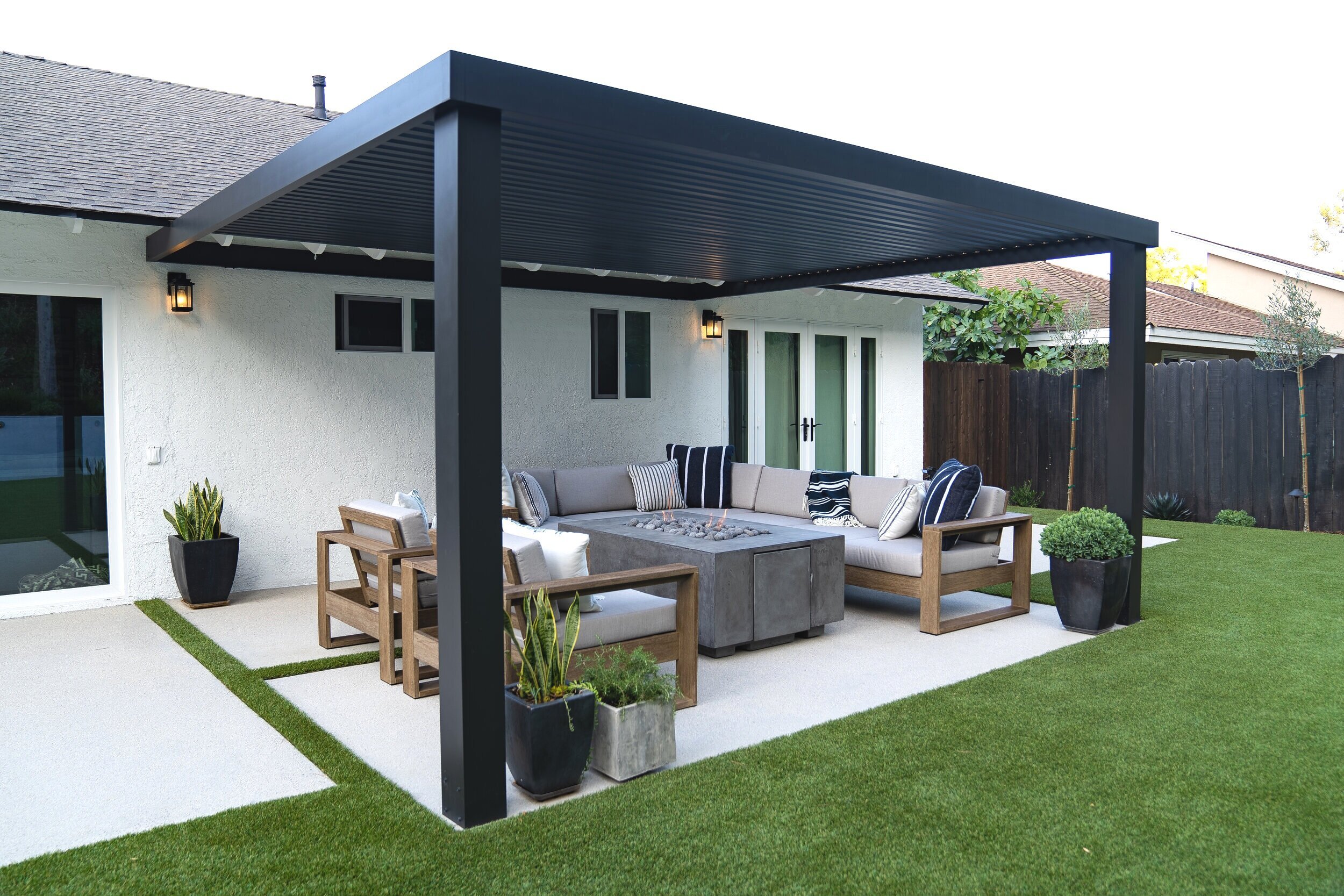 Modern black pergola covers outdoor fire pit lounge area