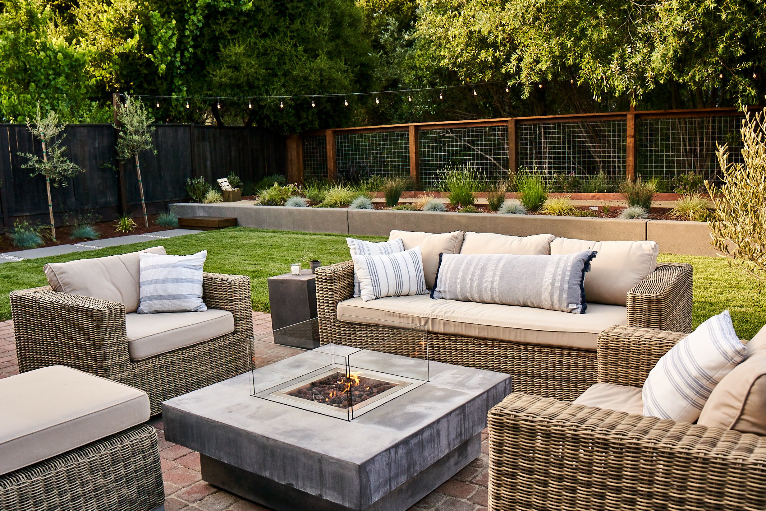 Outdoor fire pit area with comfortable outdoor couch and club chairs
