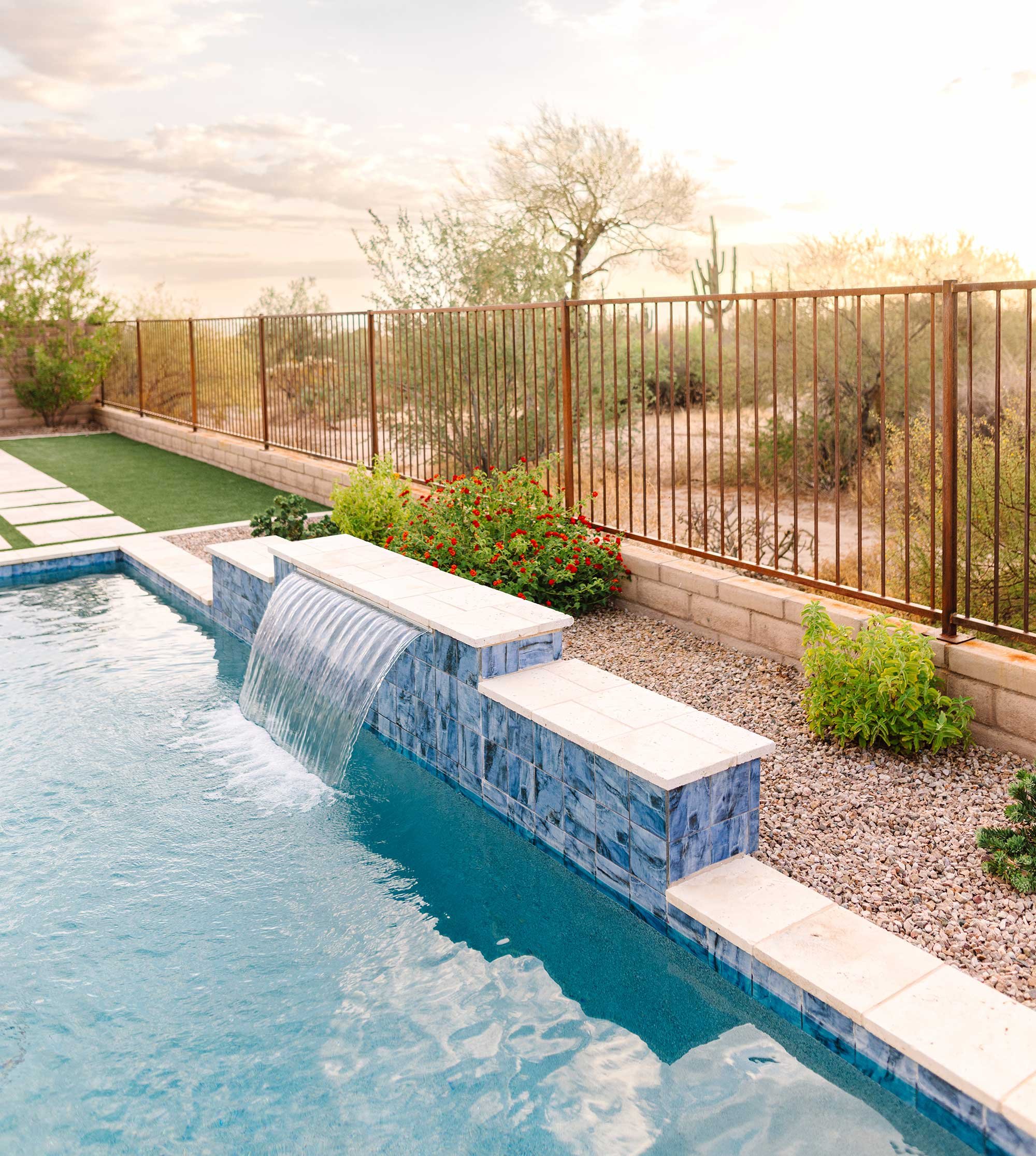 A tiled wall fountain adds the soothing sound of falling water to the yard, while the minimal corten fence provides a panoramic view of the desert landscape.